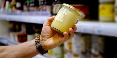 Ruka muže, který vybírá med v supermarketu