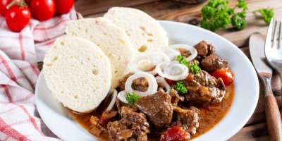 Guláš s houskovým knedlíkem a cibulí