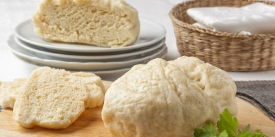 Domácí kynutý knedlík na talíři a na prkénku