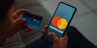 Muž s mobilem v ruce, který nahrává údaje z karty do telefonu