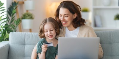 Žena s dítětem, které drží v ruce platební kartu