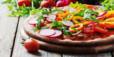 Pizza s nakrájenými ředkvičkami, rukolou a paprikou