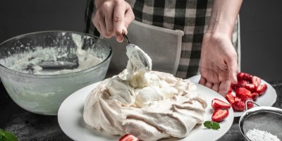 Žena, která nanáší šlehačku na dort Pavlova