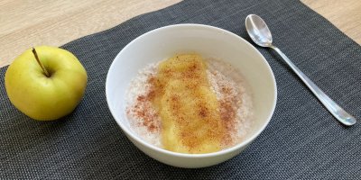 Pohanková kaše, servírovaná v bílé misce, zdobená jablečným pyré