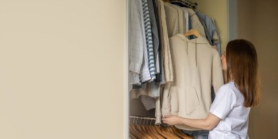 Žena vytahuje mikinu ze skříně