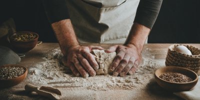 Pekař, který hněte těsto na pomoučeném vále