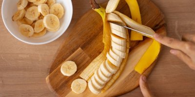 Člověk krájí banán na kolečka