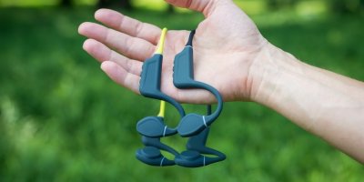 Ruka drží dvoje bezdrátová sluchátka