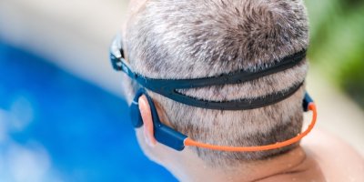 Muž s plaveckými brýlemi a bezdrátovými sluchátky