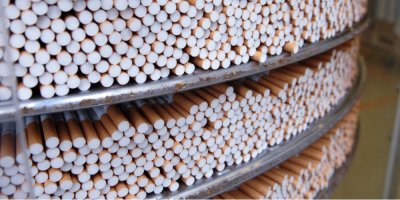 Cigarety, naskládané na sobě, umístěné v kovovém regálu