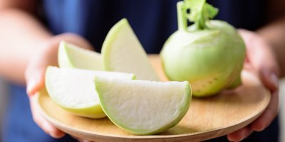 Žena drží tác s nakrájenou kedlubnou