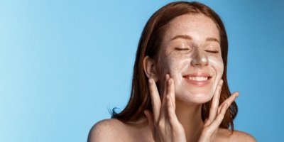 Žena, které si na pleť nanáší pleťovou masku