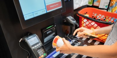 Žena v samoobslužné prodejně, kde si u pokladny markuje nákup