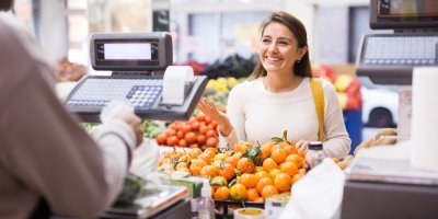 Žena u pokladny, která si povídá s prodavačkou