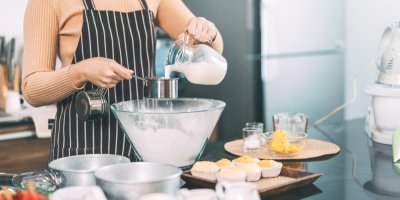 Žena odměřuje mléko do mísy