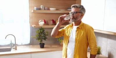 Muž pije vodu ze sklenice