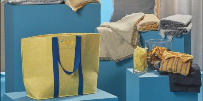 Žlutá taška Ikea, která je postavená na modrém podstavci