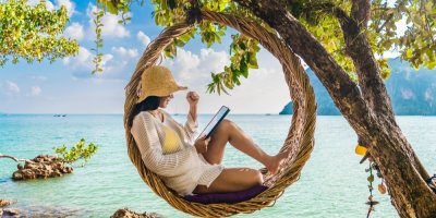 Žena, sedící v závěsném křesle na pláži