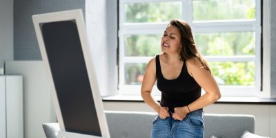 Žena se snaží si obléct džíny