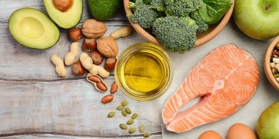 Zdravá strava na stole jako losos, olivový olej, ořechy, avokádo, brokolice v misce