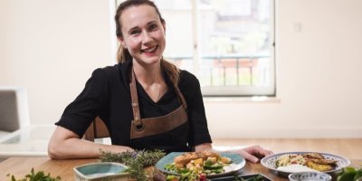 Žena sedí za stolem, kde jsou pokrmy z tofu