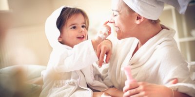 Dítě v županu maže ženě nos