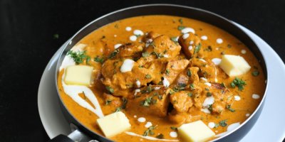 Butter chicken v pánvi s kousky másla a se smetanou