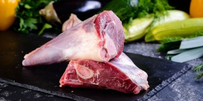 2 jehněčí kolínka na sobě, v pozadí zelenina