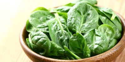 Listy špenátu v dřevěné misce