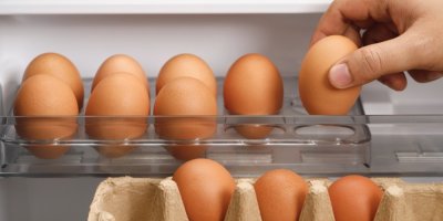 Ruka dává vejce do lednice