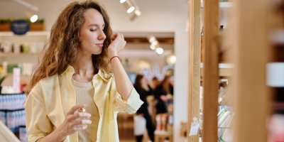 Žena v obchodě si čichá k zápěstí