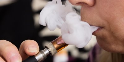 Člověk kouří e-cigaretu