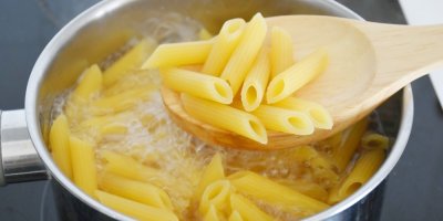 Vařící se těstoviny a několik na vařečce