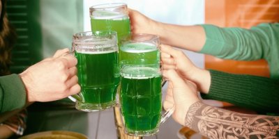 Lidé si přiťukávají zeleným pivem
