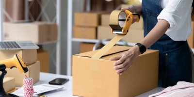 Člověk lepí krabici izolepou