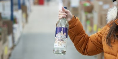 Žena drží vodku v obchodě Mere