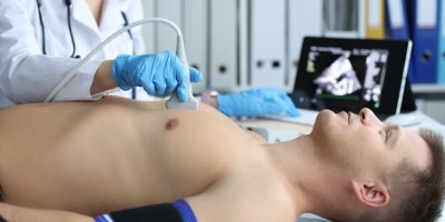 Žena vyšetřuje muže ultrazvukem