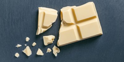 Kousky bílé čokolády na tmavém pozadí