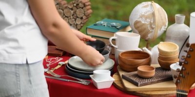 Osoba si vybírá hrníčky na garážovém výprodeji