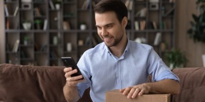 Muž v košili se dívá do mobilu