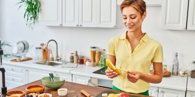 Žena loupe v kuchyni banán