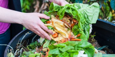 Záběr na ruce vkládající do bioodpadu další zbytky