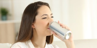 Žena pije nápoj z plechovky