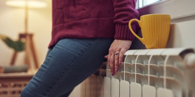 Žena se ohřívá u radiátoru