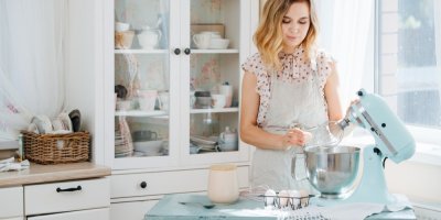 Mladá žena používá šlehač v retro stylu