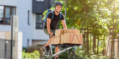 Muž jede jako messenger na kole s balíky