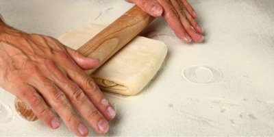Ruce, které rozvalují těsto na kremrole