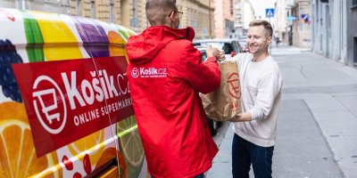 Kurýr supermarketu Košík předává muži nákup