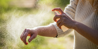 Žena si na sebe stříká repelent