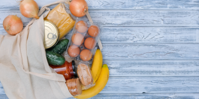 Textilní taška s potravinami na dřevěné pozadí